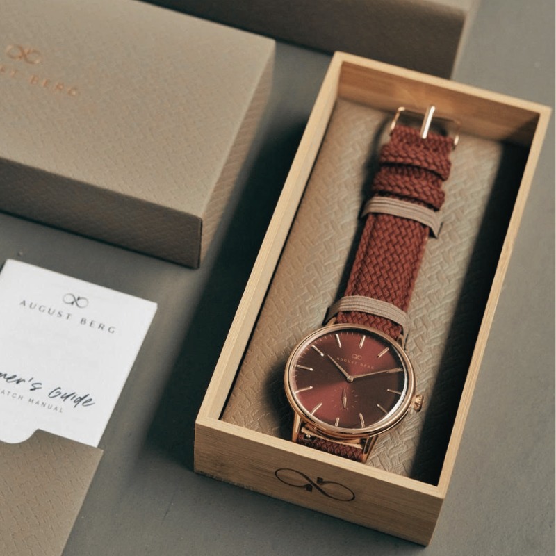August Berg watch in a wooden gift box with a burgundy woven strap